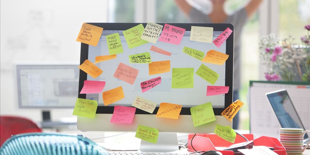 A computer monitor entirely covered in post-it notes